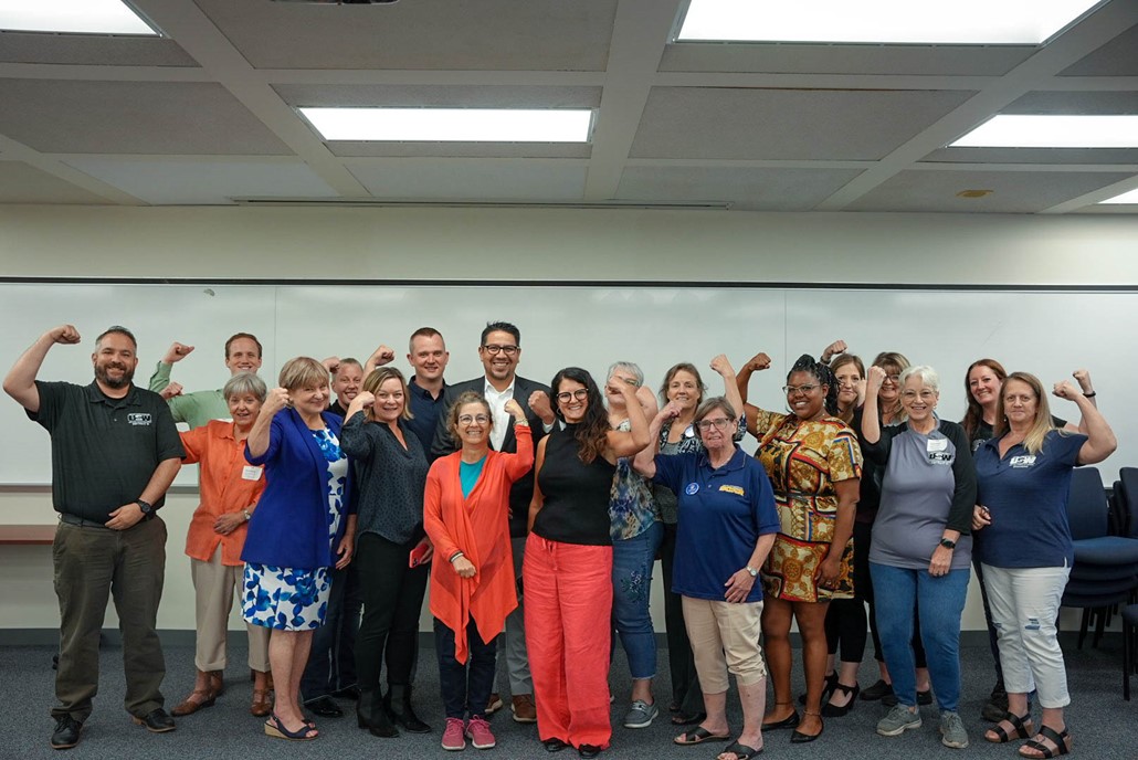 Staff from USTR smile and do the Rosie the Riveter strong arm alongside the Women of Steel union. 